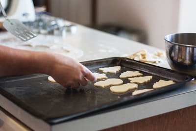 人衬assorted-shaped饼干在烤盘在厨房
